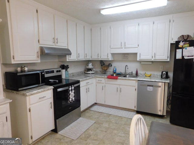 kitchen with under cabinet range hood, stainless steel appliances, a sink, and light countertops