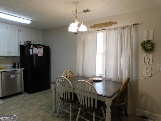 dining space with a textured ceiling, visible vents, and a healthy amount of sunlight