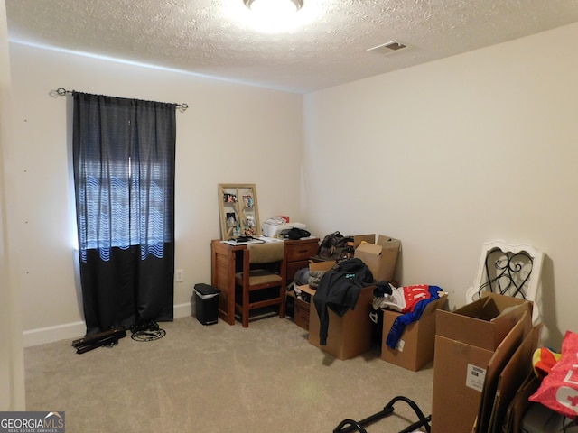 interior space with carpet floors, visible vents, a textured ceiling, and baseboards