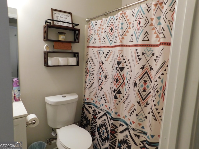 bathroom with toilet, curtained shower, and vanity