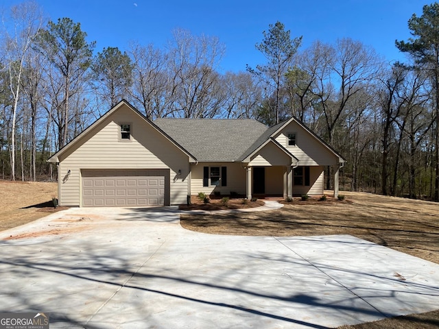 view of front of home featuring concrete driveway, a shingled roof, and an attached garage