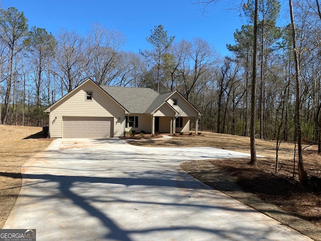 view of front of home featuring concrete driveway, roof with shingles, and an attached garage