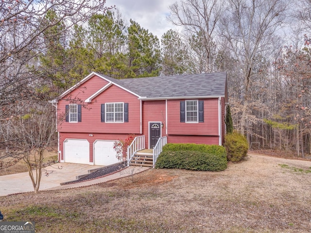 raised ranch featuring a garage and driveway