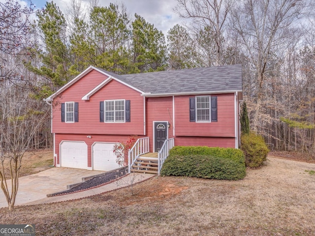 raised ranch with concrete driveway and an attached garage