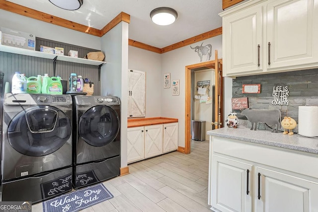 washroom with light wood-style floors, baseboards, washer and dryer, cabinet space, and crown molding