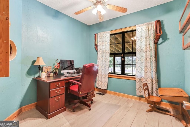 office area with light wood finished floors, ceiling fan, baseboards, and a textured wall