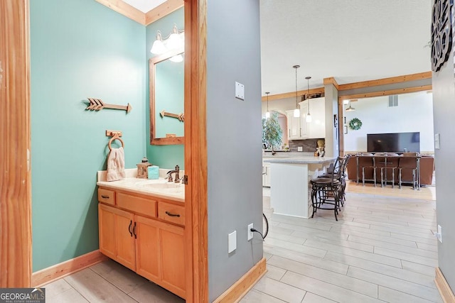 bathroom with baseboards, visible vents, vanity, and decorative backsplash