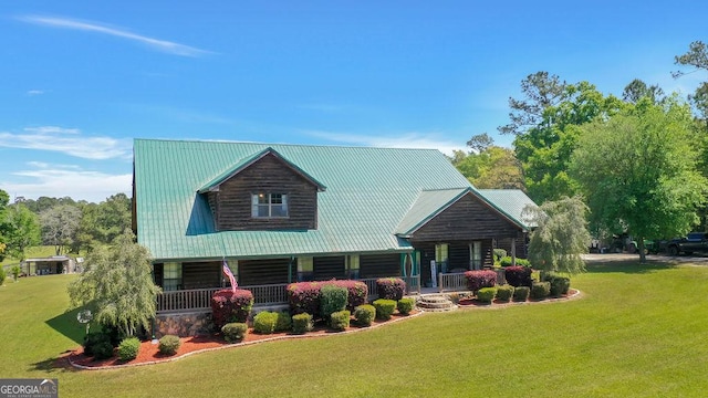 log-style house with covered porch, metal roof, and a front lawn