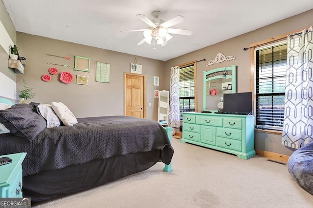 bedroom featuring light carpet, baseboards, visible vents, and a ceiling fan