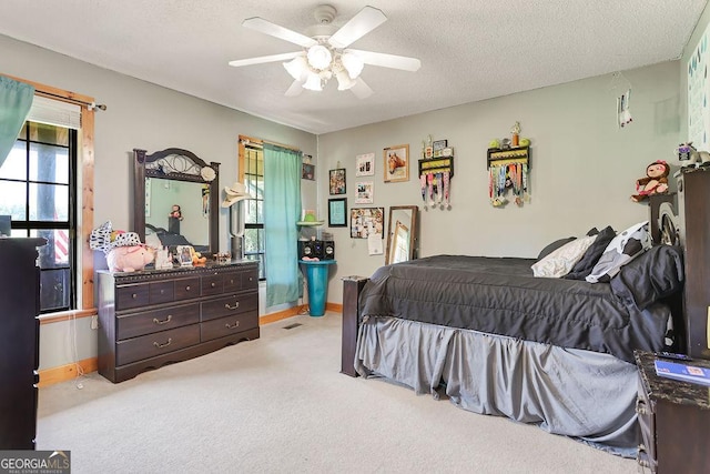 bedroom with carpet floors, a textured ceiling, baseboards, and a ceiling fan