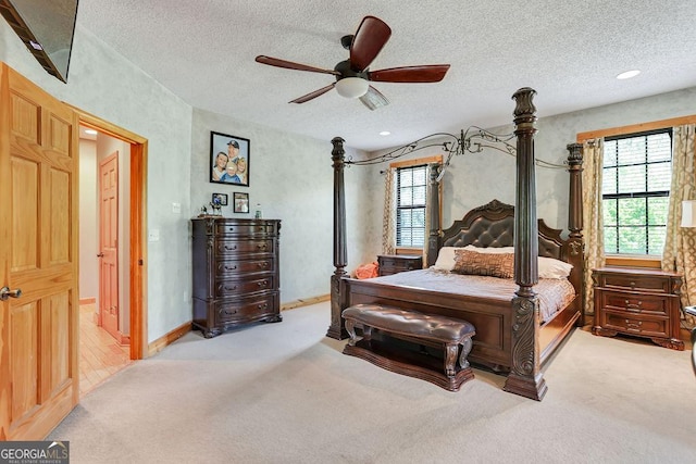 bedroom with carpet floors, ceiling fan, baseboards, and a textured ceiling