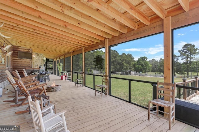 wooden deck with an outdoor fire pit and a yard