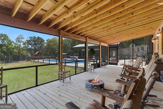 wooden deck featuring a yard, an outdoor fire pit, fence, and a fenced in pool