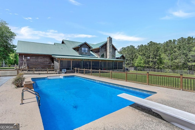 view of pool featuring a fenced in pool, a sunroom, fence, a yard, and a patio area