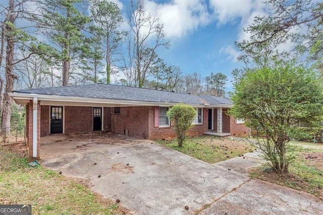 ranch-style home featuring driveway, a carport, and brick siding