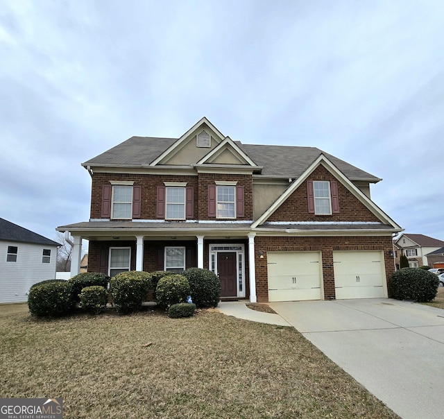 view of front facade featuring a garage, driveway, brick siding, and a front yard