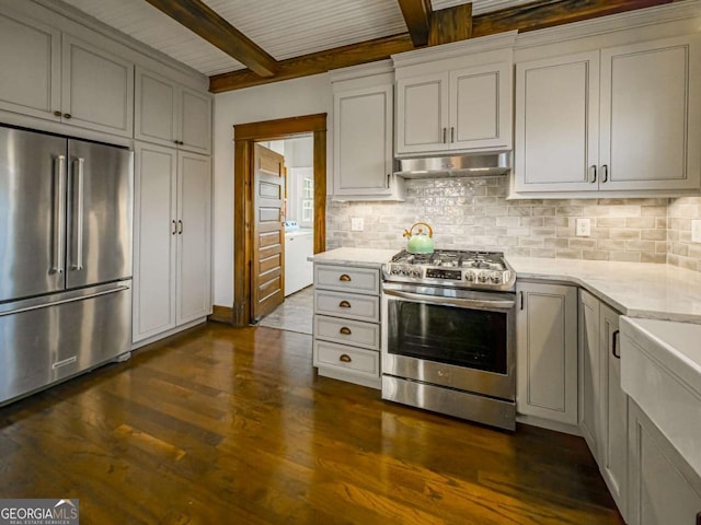 kitchen featuring stainless steel appliances, tasteful backsplash, under cabinet range hood, and light stone countertops