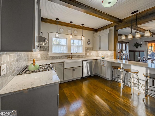 kitchen featuring dark wood-style floors, decorative backsplash, stainless steel dishwasher, a sink, and beamed ceiling