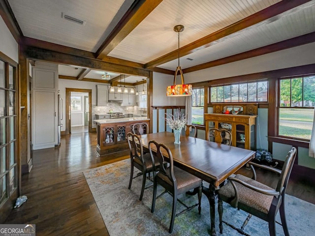 dining area featuring dark wood-style floors, visible vents, and beam ceiling