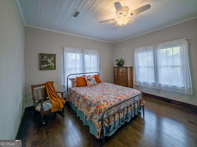 bedroom with baseboards, hardwood / wood-style floors, visible vents, and crown molding