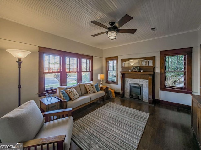 living room featuring ceiling fan, dark wood-type flooring, a fireplace with flush hearth, visible vents, and baseboards