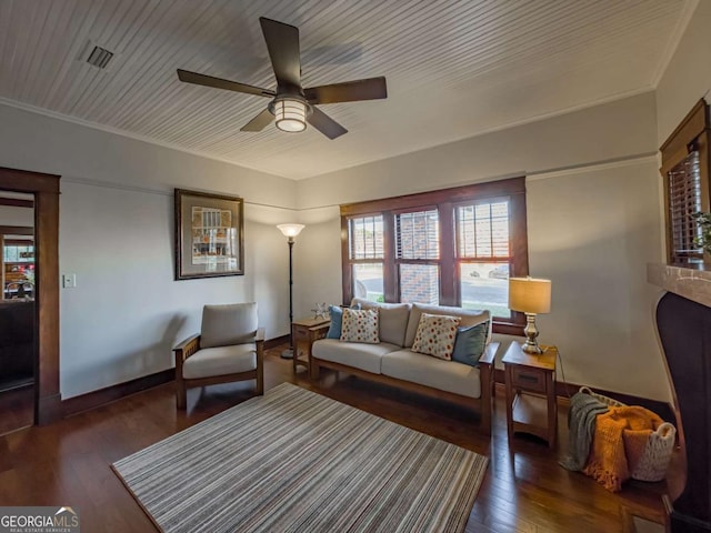 living area with ceiling fan, visible vents, hardwood / wood-style flooring, and baseboards