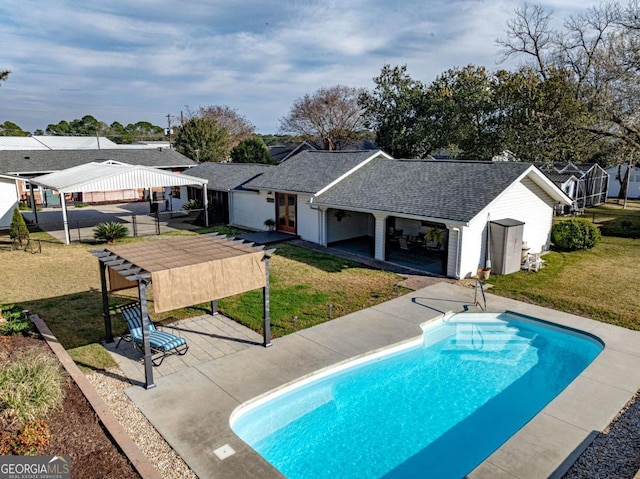 outdoor pool with a residential view, a patio area, and a yard