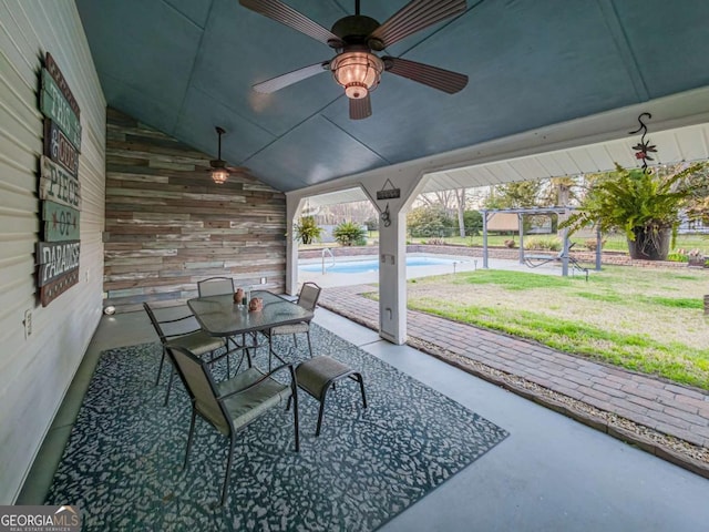 view of patio featuring outdoor dining space, a ceiling fan, and an outdoor pool