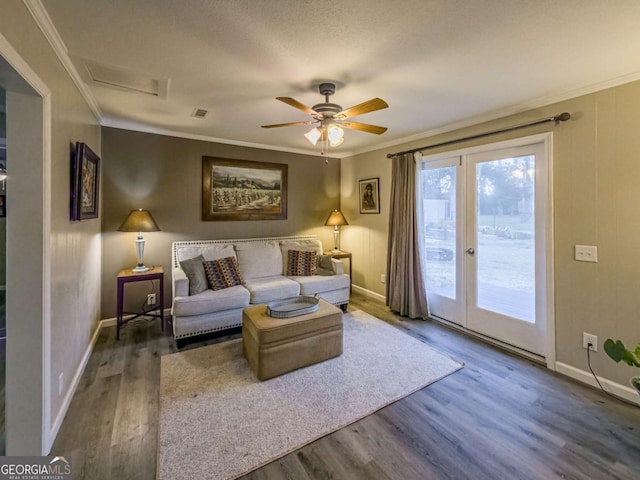 living room featuring baseboards, wood finished floors, and crown molding