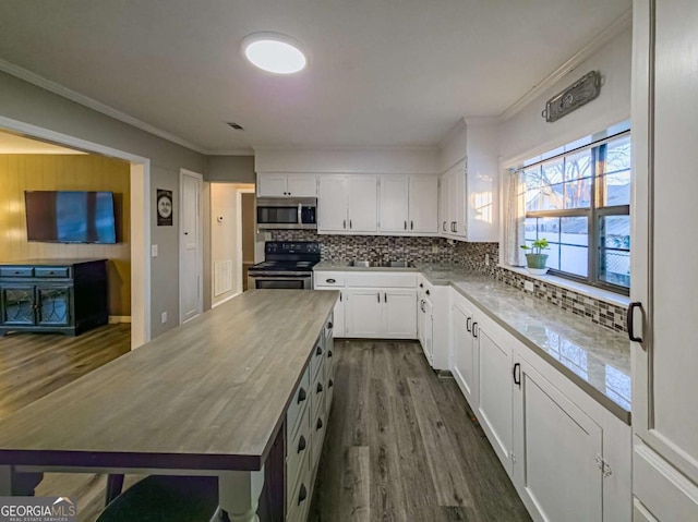 kitchen with dark wood-style floors, appliances with stainless steel finishes, decorative backsplash, and a center island