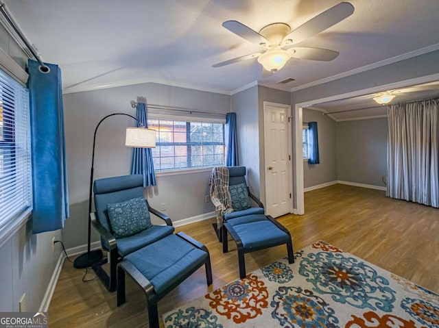 living area featuring crown molding, visible vents, vaulted ceiling, and wood finished floors