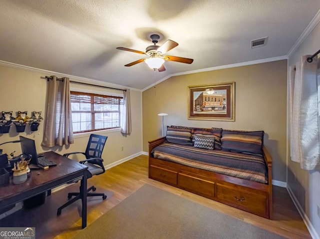 bedroom featuring lofted ceiling, crown molding, visible vents, and wood finished floors