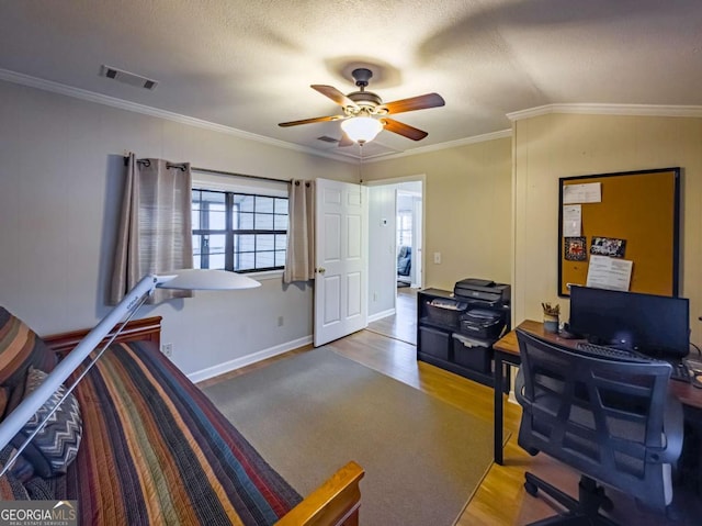 office space featuring visible vents, a textured ceiling, ornamental molding, and wood finished floors