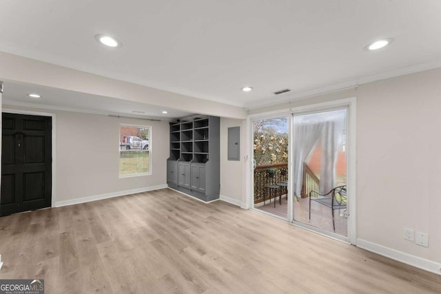 unfurnished room featuring light wood finished floors, recessed lighting, electric panel, and baseboards