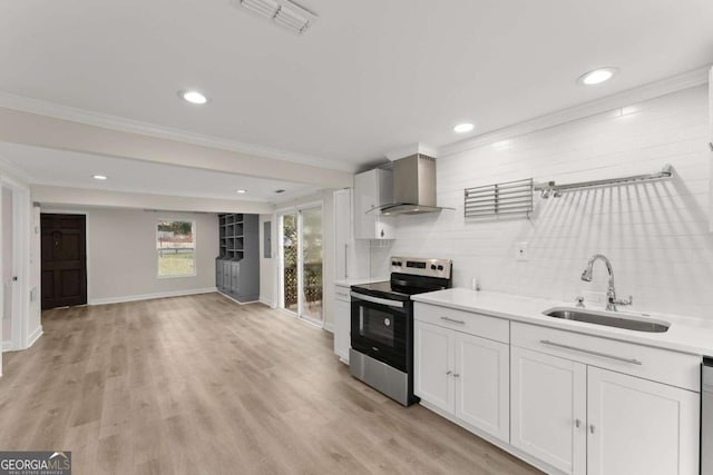 kitchen with visible vents, electric stove, wall chimney exhaust hood, ornamental molding, and a sink