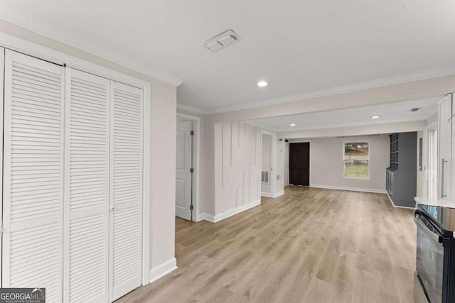 unfurnished living room with baseboards, light wood-style flooring, visible vents, and crown molding