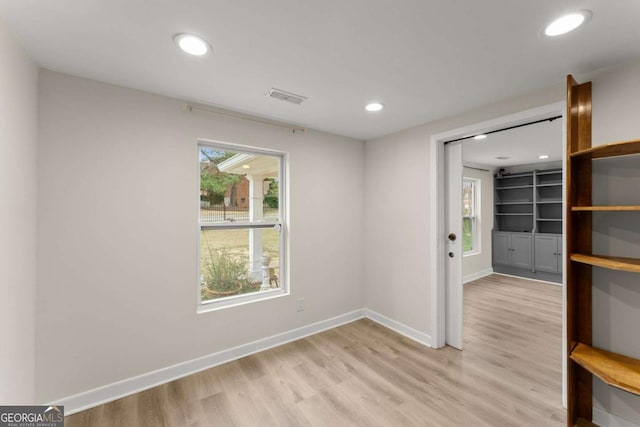 empty room featuring recessed lighting, light wood-type flooring, visible vents, and baseboards