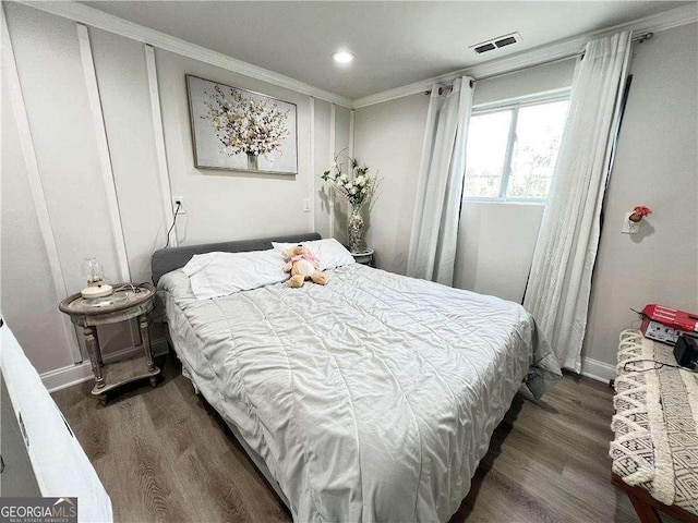 bedroom with baseboards, crown molding, visible vents, and dark wood-type flooring