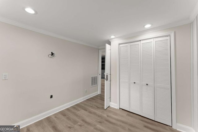 unfurnished bedroom with ornamental molding, light wood-type flooring, visible vents, and baseboards