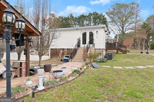 rear view of house featuring french doors, a yard, stairway, an outdoor fire pit, and a patio area