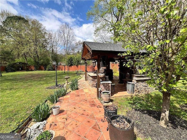 view of yard featuring a patio area, fence, and an outdoor structure