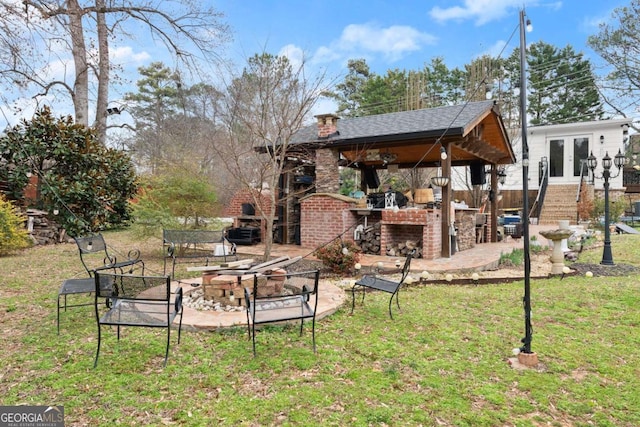 view of yard featuring an outdoor brick fireplace, an outdoor fire pit, a patio, and french doors