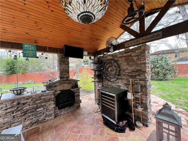 view of patio / terrace featuring an outdoor stone fireplace and fence