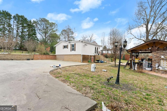 view of side of home with concrete driveway and brick siding