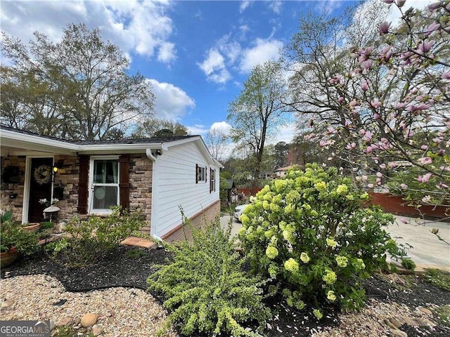 view of side of home with stone siding