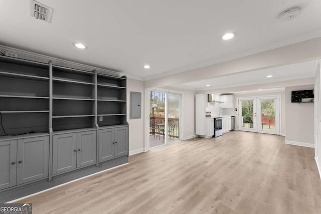 unfurnished living room featuring light wood finished floors, ornamental molding, visible vents, and electric panel