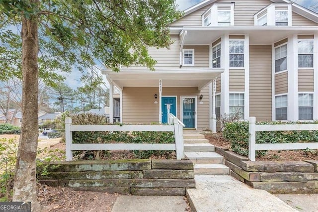 view of front of property with covered porch and fence