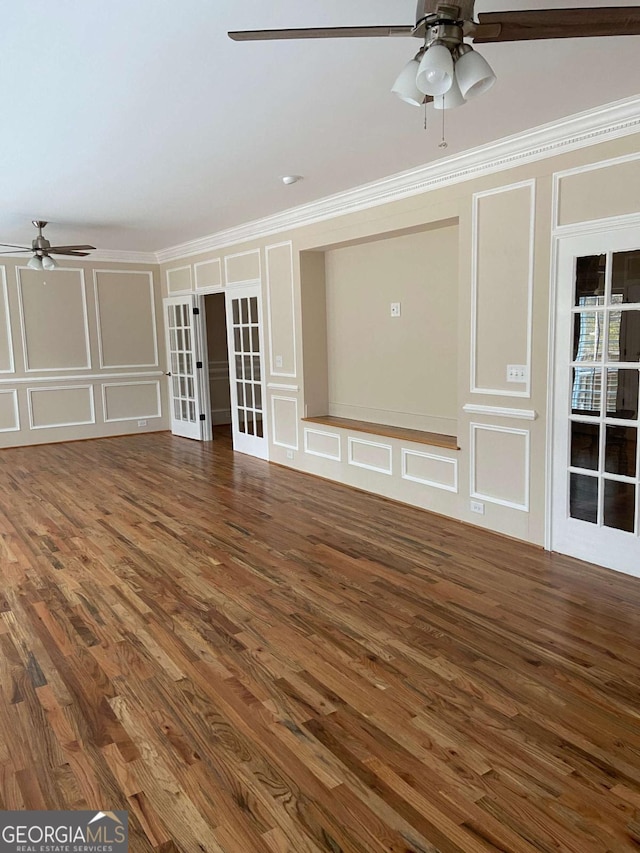 unfurnished living room featuring ceiling fan, ornamental molding, and a decorative wall