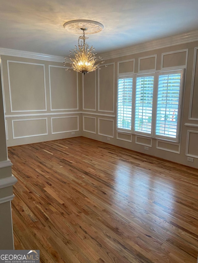 interior space with a decorative wall, a notable chandelier, and wood finished floors