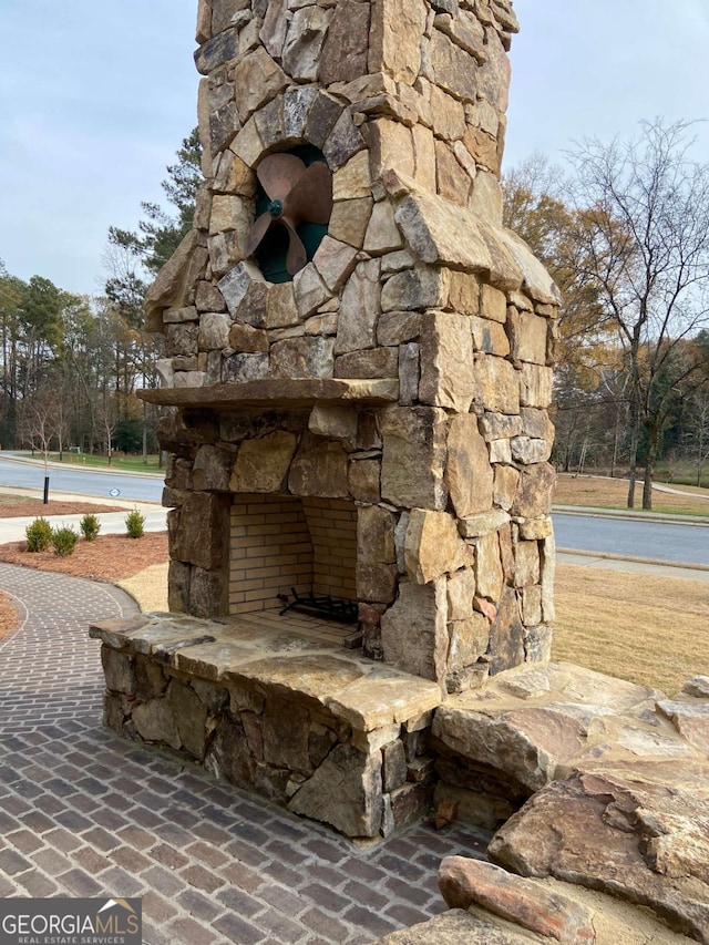 exterior details with an outdoor stone fireplace